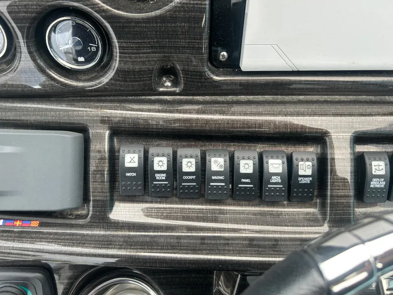 Slide: The Image of Dashboard controls of a 2022 Monterey 295 Sport Yacht with various switches and gauges. - 12