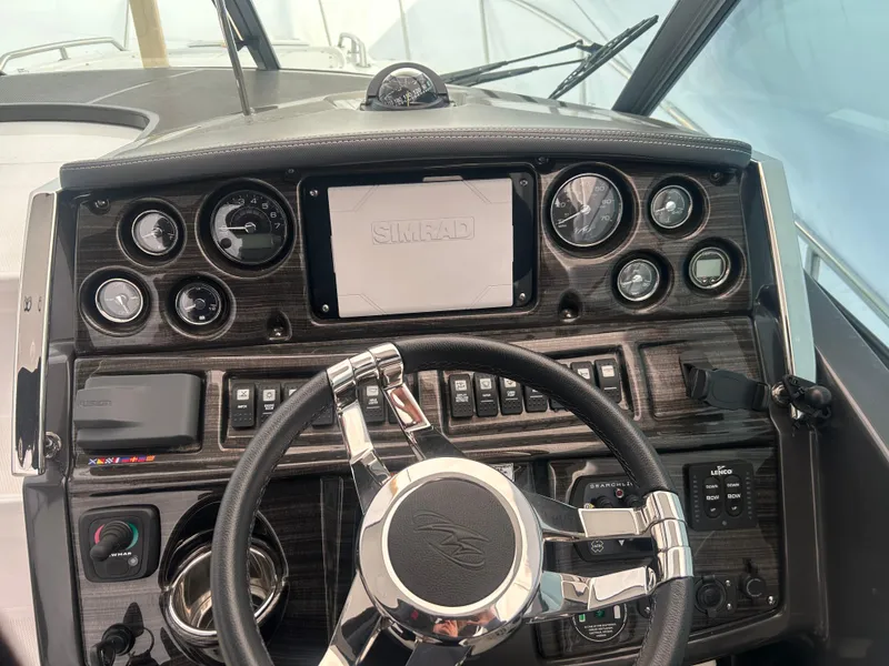 Slide: The Image of Dashboard of a 2022 Monterey 295 Sport Yacht with steering wheel and control gauges. - 14