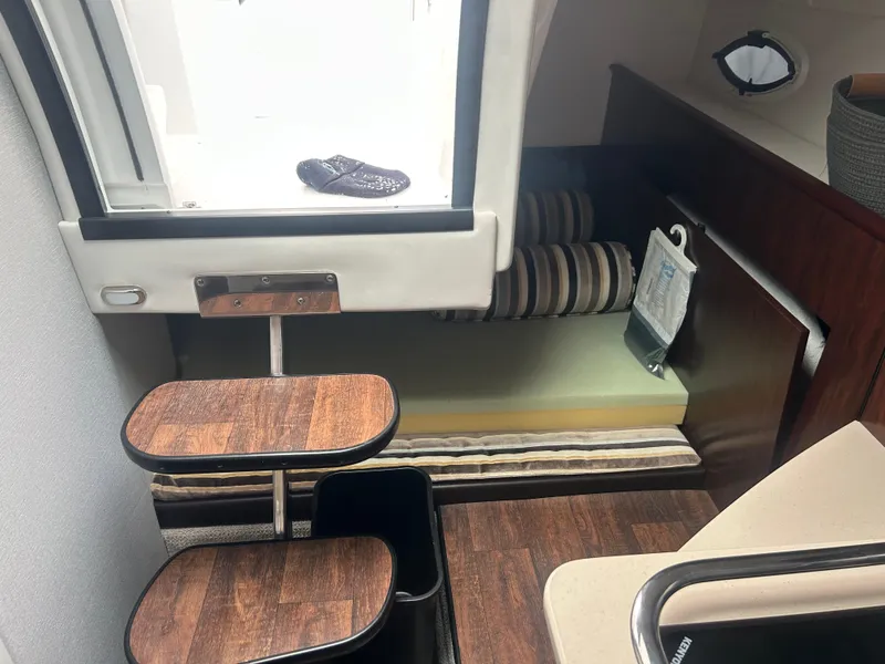 Slide: The Image of Interior of 2022 Monterey 295 Sport Yacht with wooden steps and cozy seating area. - 16