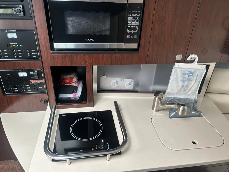 Slide: The Image of 2022 Monterey 295 Sport Yacht kitchen with microwave, stove, and sink. - 18