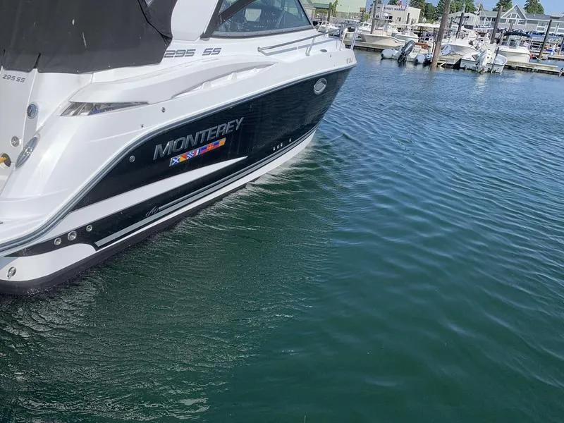 Slide: The Image of 2022 Monterey 295 Sport Yacht docked in marina, side view. - 2