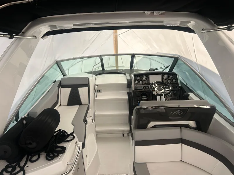 Slide: The Image of 2022 Monterey 295 Sport Yacht interior with helm, seating, and dashboard. - 5