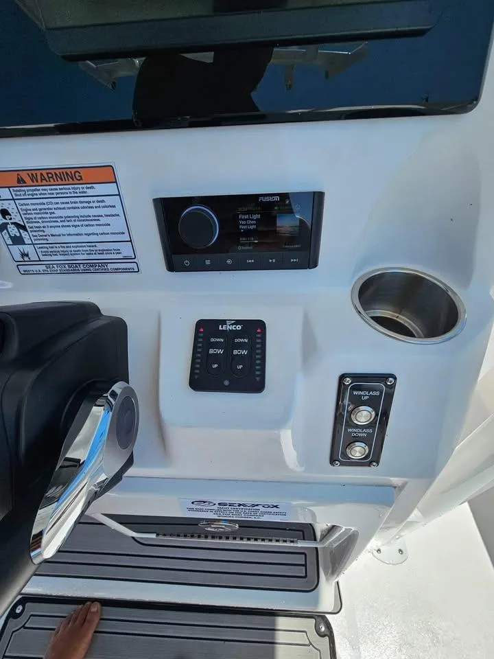 Slide: The Image of 2023 Sea Fox 268 Commander boat dashboard with controls and cup holder. - 8