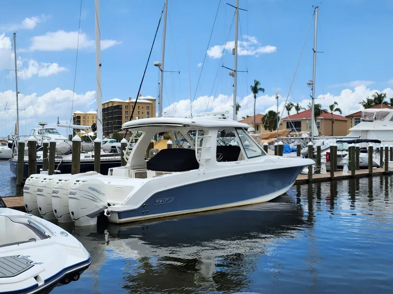 The Image of 2019 Boston Whaler 380 Realm docked in a marina under a clear blue sky. - 0