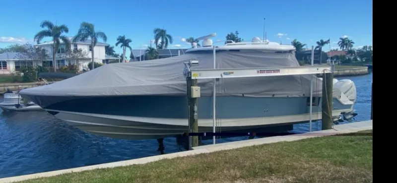 Slide: The Image of 2019 Boston Whaler 380 Realm boat covered and docked by a canal. - 4
