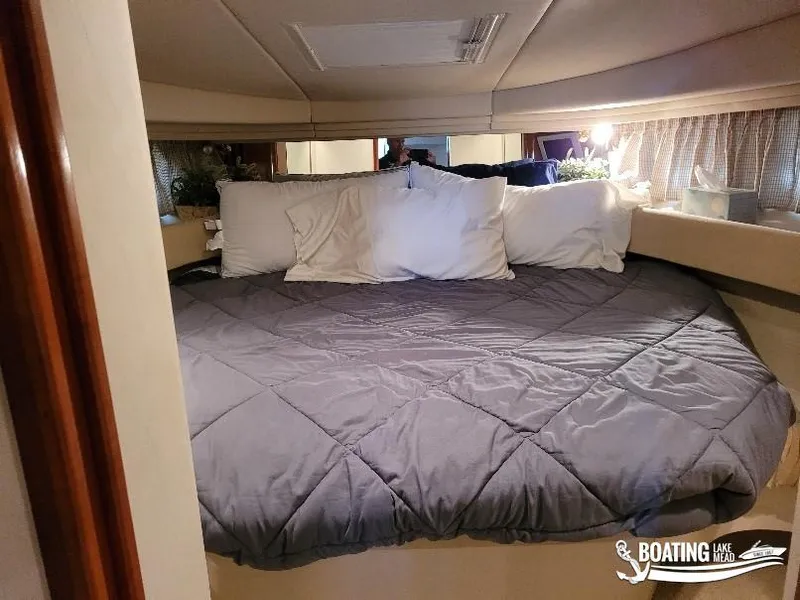Slide: The Image of Cozy cabin interior of 2003 Sea Ray 380 Sundancer with plush bedding. - 17