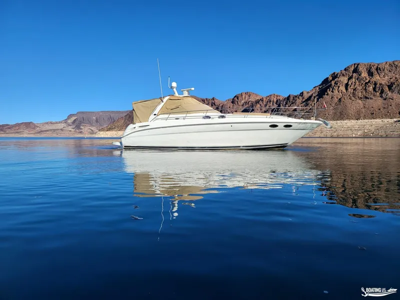 Slide: The Image of 2003 Sea Ray 380 Sundancer yacht on calm water with mountainous backdrop. - 3