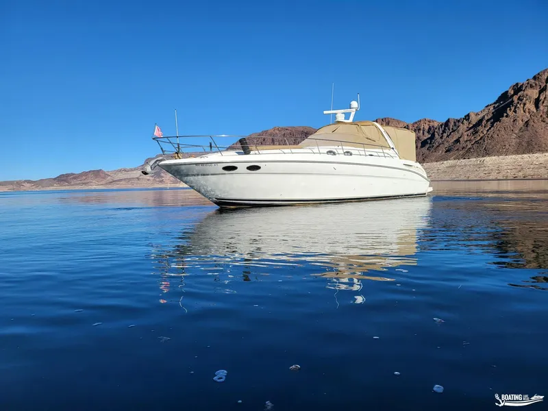 Slide: The Image of 2003 Sea Ray 380 Sundancer yacht on calm water with mountainous backdrop. - 4