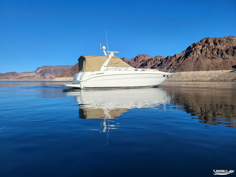 Slide: The Image of 2003 Sea Ray 380 Sundancer yacht on calm water with mountainous backdrop. - 6