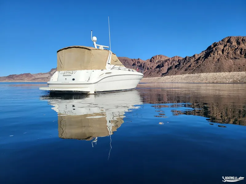 Slide: The Image of 2003 Sea Ray 380 Sundancer yacht on calm water with rocky landscape background. - 7