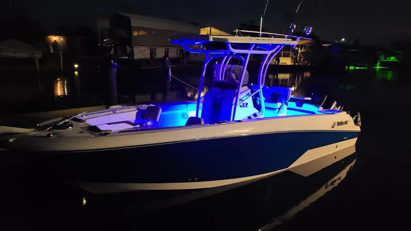 Slide: The Image of 2019 Wellcraft 242 Fisherman boat illuminated at night with blue interior lights. - 20