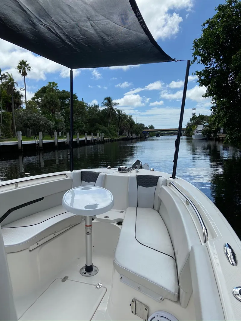 Slide: The Image of 2019 Wellcraft 242 Fisherman boat on a scenic river with lush greenery and blue sky. - 21