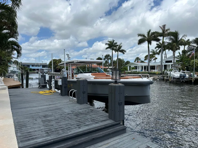 Slide: The Image of 2018 Axopar 370 SUN TOP docked by palm trees under a cloudy sky. - 1