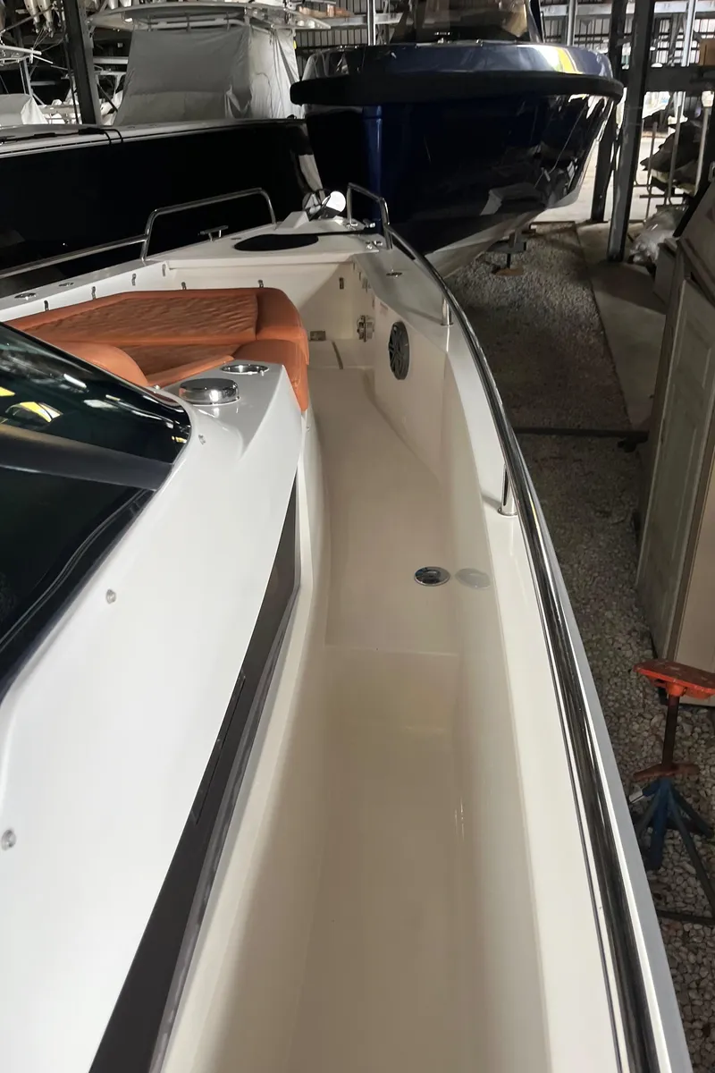 Slide: The Image of 2018 Axopar 370 SUN TOP boat in storage, showcasing sleek design and spacious deck. - 17