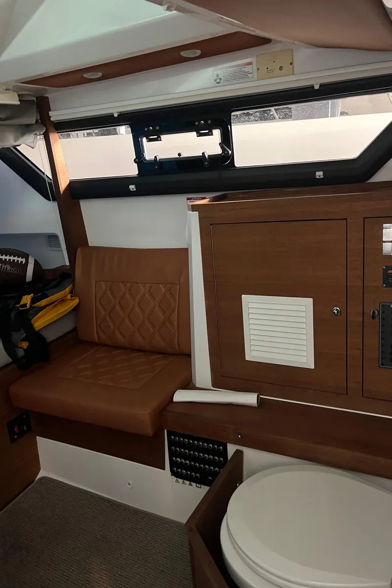 Slide: The Image of 2018 Axopar 370 SUN TOP cabin interior with seating and storage. - 18