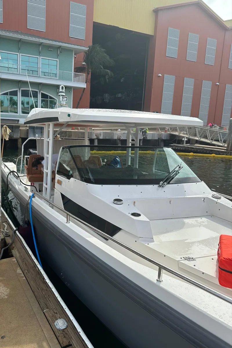 Slide: The Image of 2018 Axopar 370 SUN TOP boat docked near dry storage building. - 2