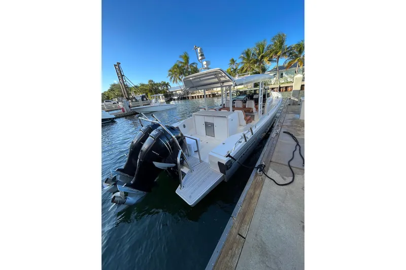 Slide: The Image of 2018 Axopar 370 SUN TOP boat docked, featuring dual outboard motors and sleek design. - 3