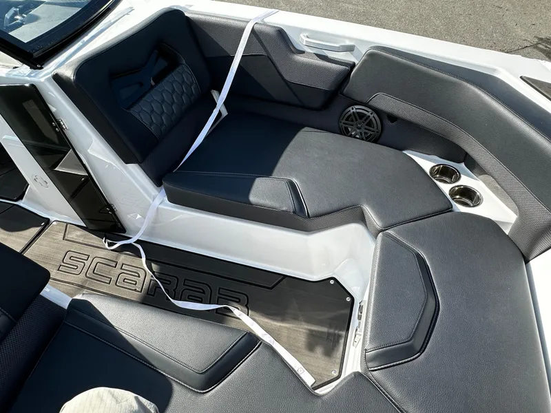 Slide: The Image of 2024 Scarab 235 Wake ID boat interior with gray seating and cup holders. - 18