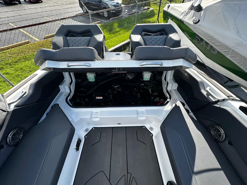 Slide: The Image of 2024 Scarab 235 Wake ID boat interior with open engine compartment, showcasing seating and design. - 30