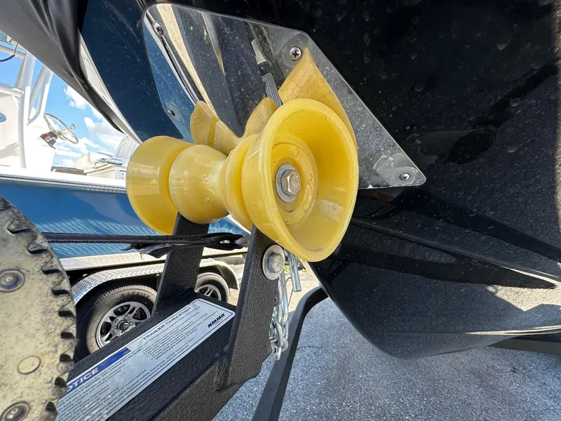 Slide: The Image of 2024 Scarab 235 Wake ID boat trailer with yellow roller detail. - 5