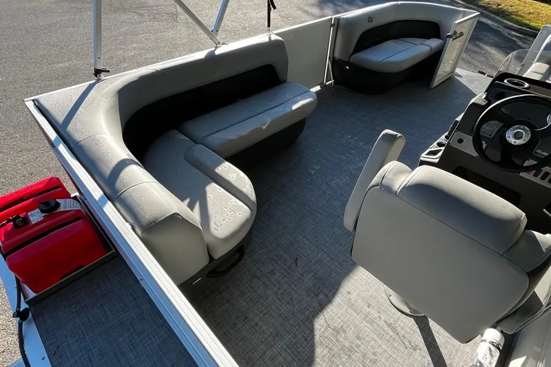 Slide: The Image of 2025 Sun Tracker Party Barge 18 DLX interior with gray seating and steering console. - 4