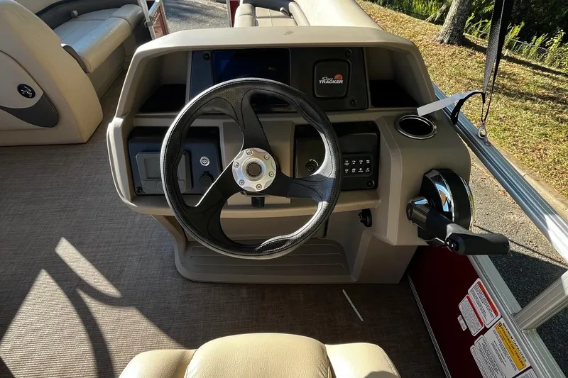 Slide: The Image of 2025 Sun Tracker Party Barge 18 DLX steering console with controls and seating. - 6