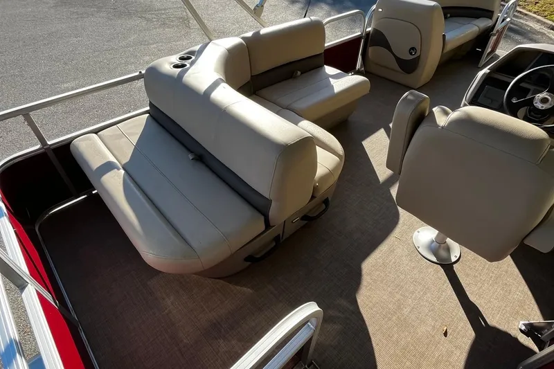 Slide: The Image of 2025 Sun Tracker Party Barge 18 DLX interior with beige seating and steering console. - 7