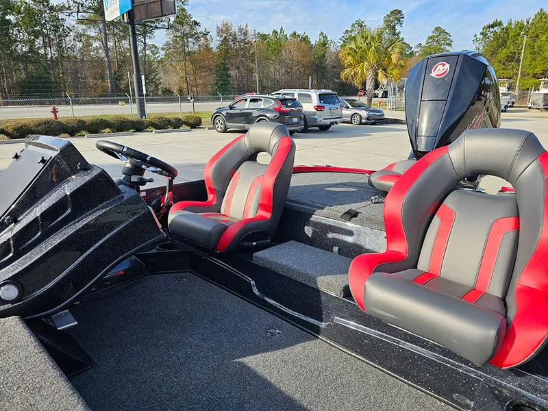 Slide: The Image of 2025 Nitro Z18 boat with red and gray seats, parked outdoors. - 11