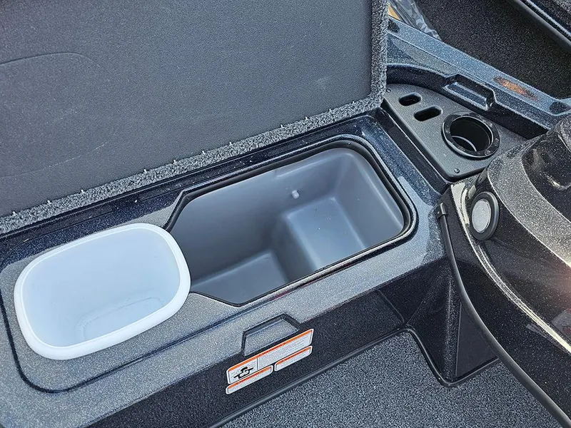 Slide: The Image of Open storage compartment in 2025 Nitro Z18 boat, featuring cup holder and organizer. - 25