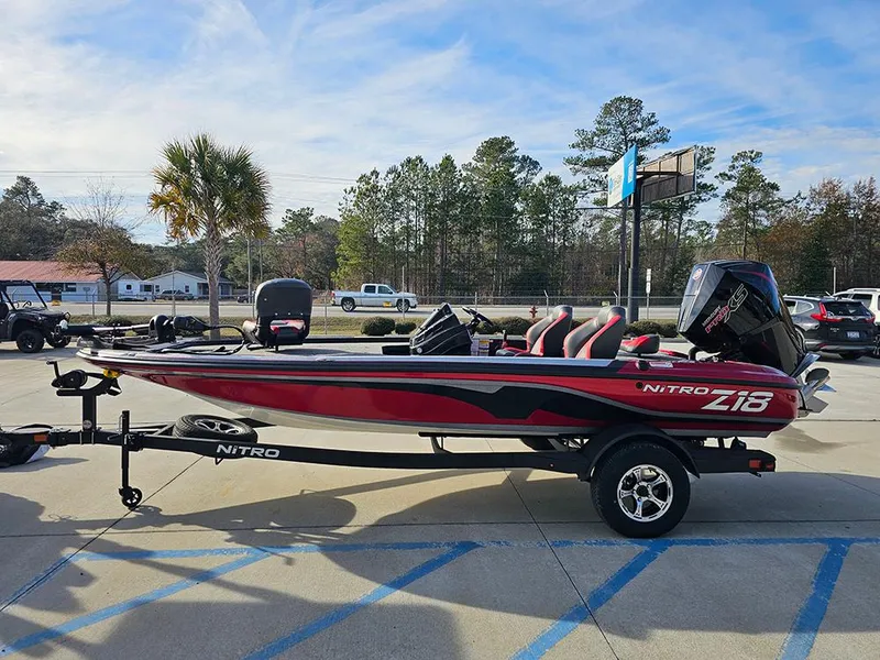 Slide: The Image of 2025 Nitro Z18 boat in parking lot, red and black design, clear sky background. - 6