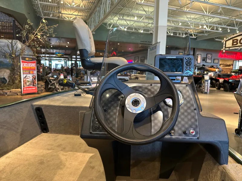 Slide: The Image of 2025 Tracker Bass Tracker Classic Limited boat dashboard with steering wheel and controls. - 2