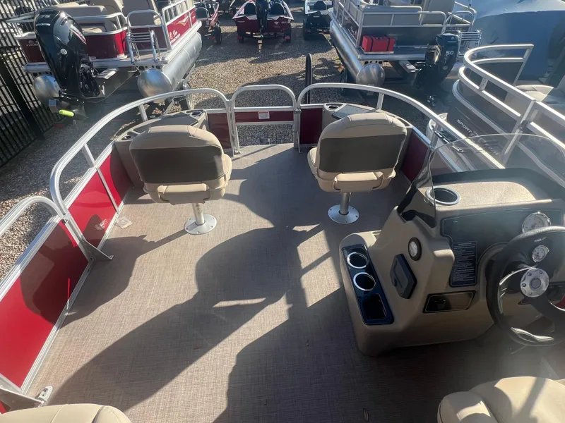 Slide: The Image of 2025 Sun Tracker Bass Buggy 18 DLX pontoon boat interior with seating and steering console. - 2