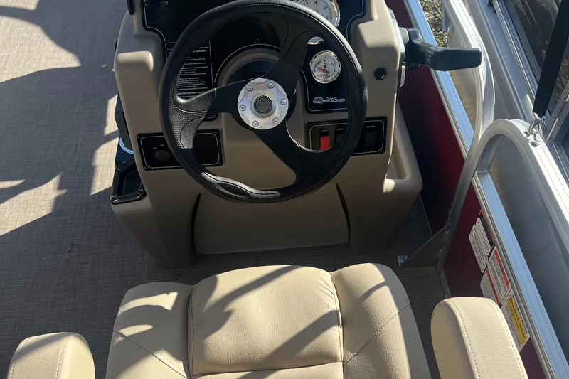 Slide: The Image of 2025 Sun Tracker Bass Buggy 18 DLX steering console with beige seating. - 4