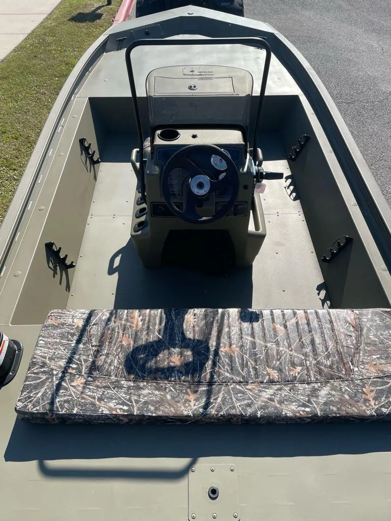 Slide: The Image of 2025 Tracker Grizzly 1860 CC boat interior with camo seating and steering console. - 3