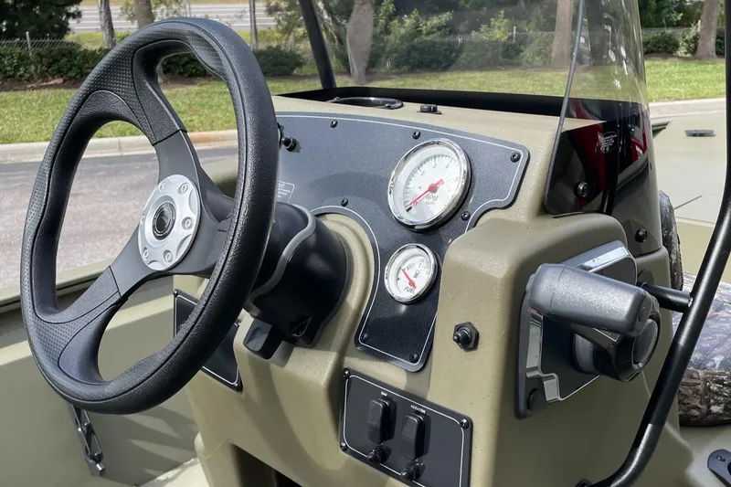 Slide: The Image of 2025 Tracker Grizzly 1860 CC boat dashboard with steering wheel and gauges. - 4