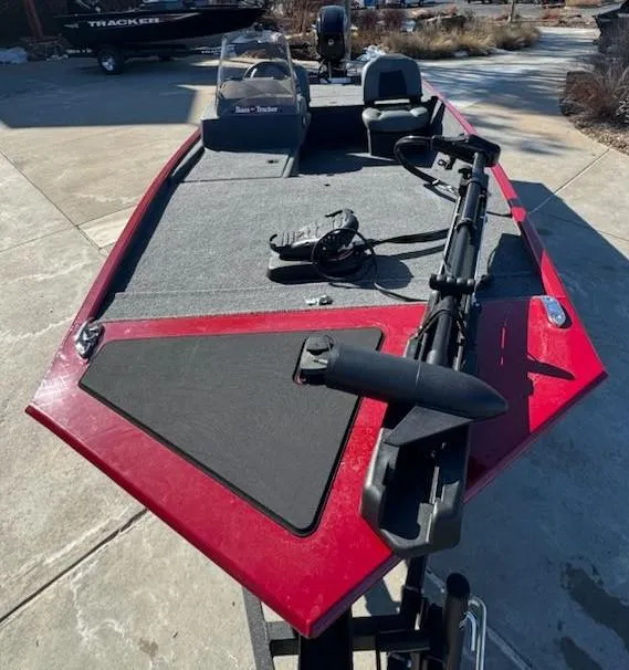 Slide: The Image of 2025 Tracker Bass Tracker Classic XL boat with red exterior, docked on concrete. - 2