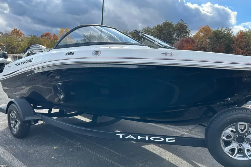 The Image of 2025 Tahoe 185 S boat on trailer, parked outdoors with autumn trees in background. - 0