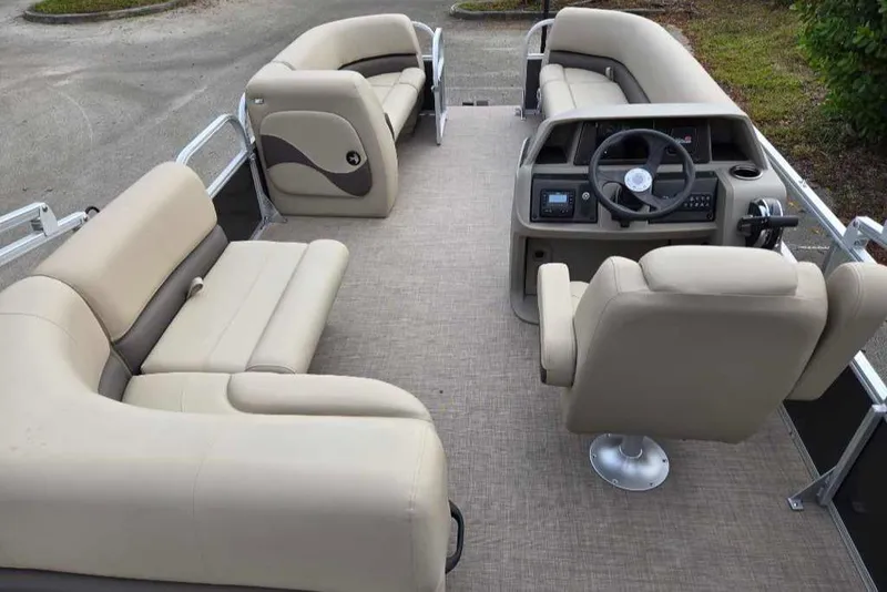 Slide: The Image of 2025 Sun Tracker Party Barge 18 DLX interior with beige seating and modern helm. - 3
