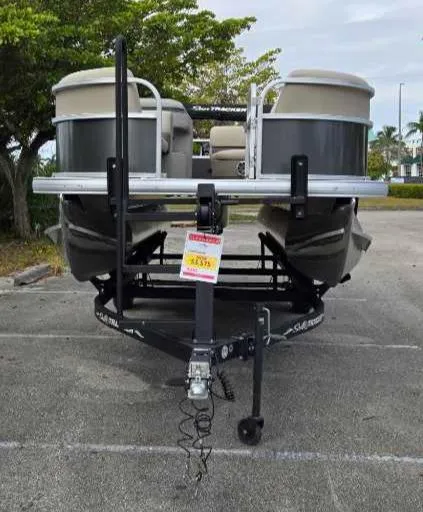 Slide: The Image of 2025 Sun Tracker Party Barge 18 DLX pontoon boat in parking lot. - 4