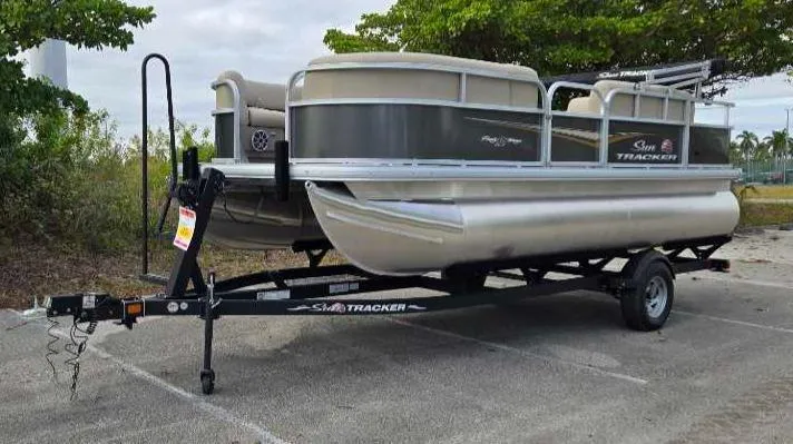 Slide: The Image of 2025 Sun Tracker Party Barge 18 DLX pontoon boat on trailer in parking lot. - 8