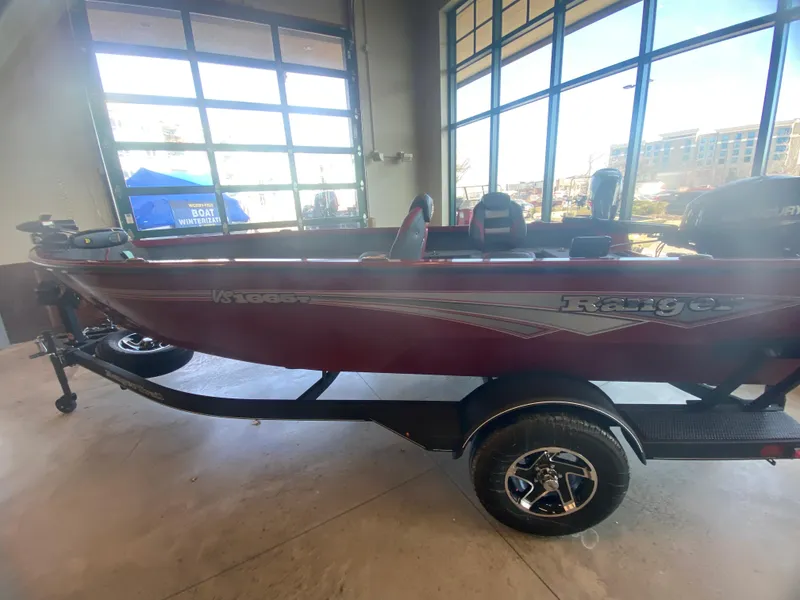 Slide: The Image of 2025 Ranger VS1665T boat displayed indoors with large windows in the background. - 1