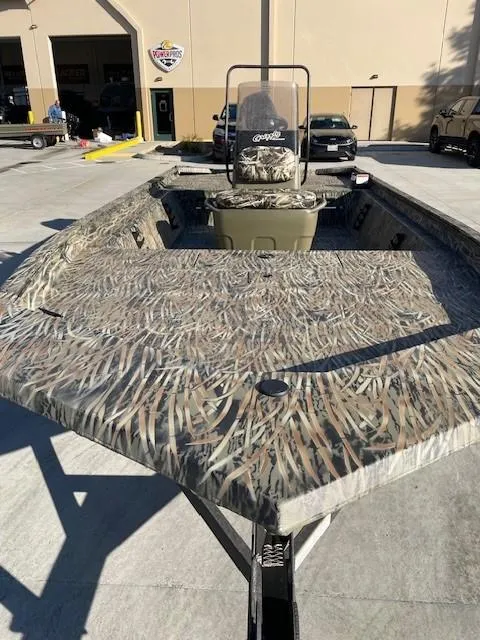 Slide: The Image of 2025 Tracker Grizzly 1860 CC boat with camouflage design in a parking lot. - 4