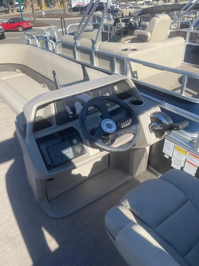 Slide: The Image of 2025 Sun Tracker Party Barge 18 DLX interior with steering console and seating. - 2