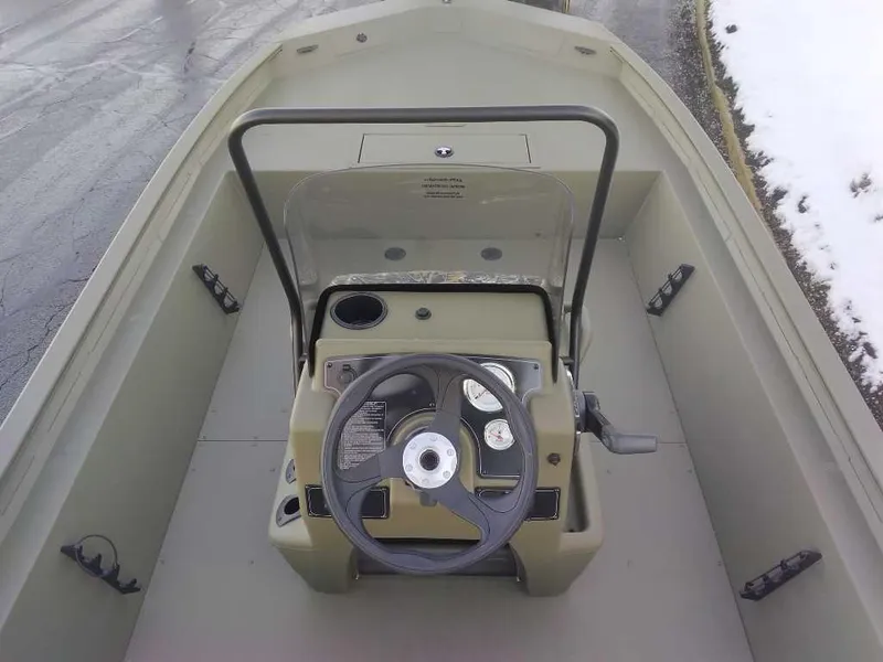 Slide: The Image of 2025 Tracker Grizzly 1860 CC boat interior with steering console and controls. - 2