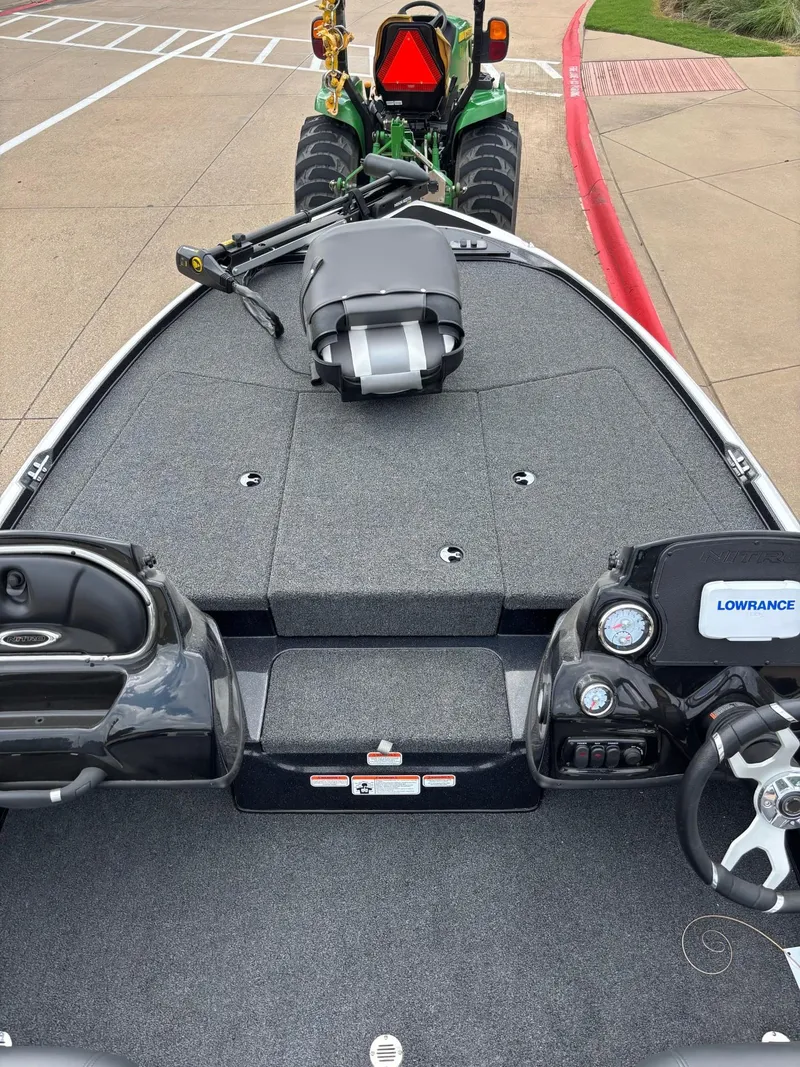 Slide: The Image of 2025 Nitro Z17 boat interior with dual seats and steering wheel, parked on concrete. - 4