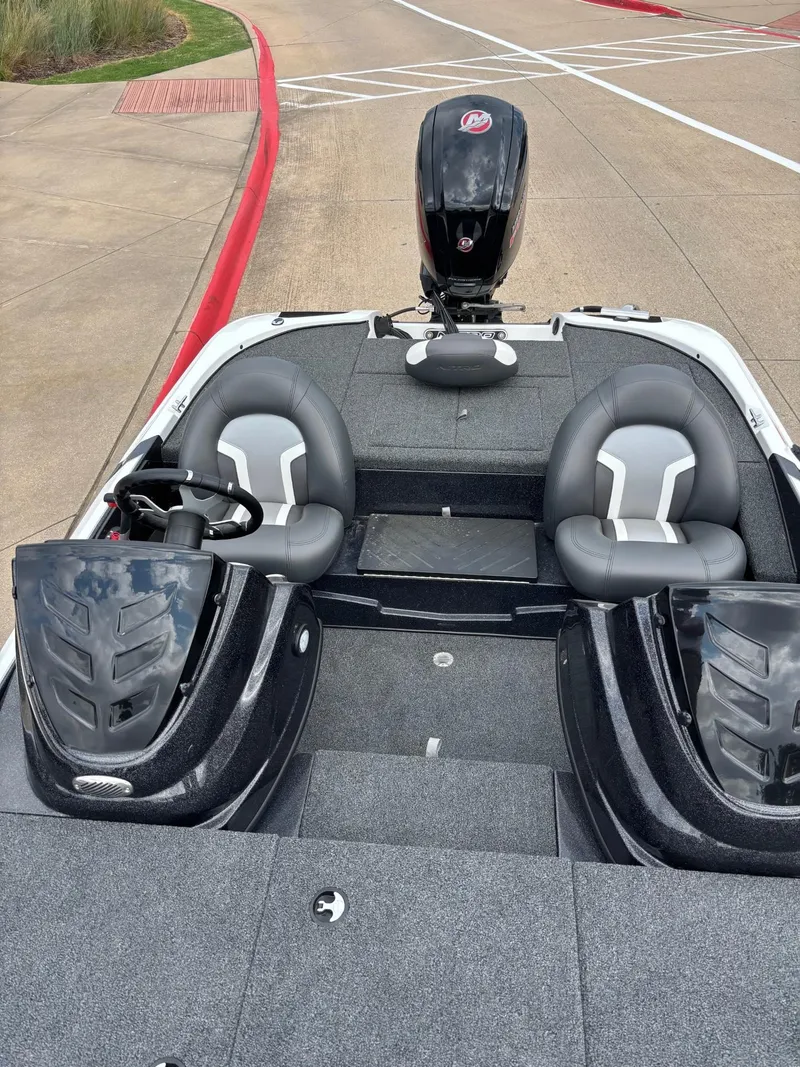Slide: The Image of 2025 Nitro Z17 boat interior with steering wheel and seating, parked outdoors. - 5