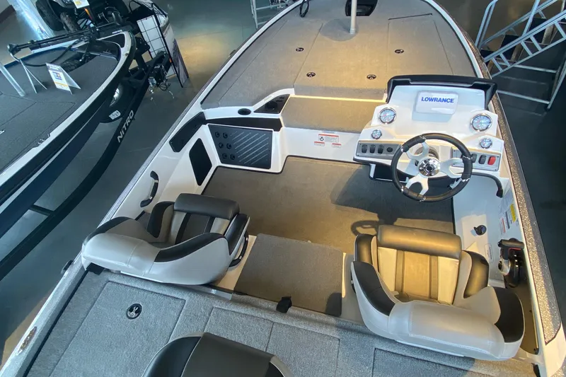 Slide: The Image of 2025 Nitro Z18 boat interior with steering wheel and seating, featuring Lowrance electronics. - 2