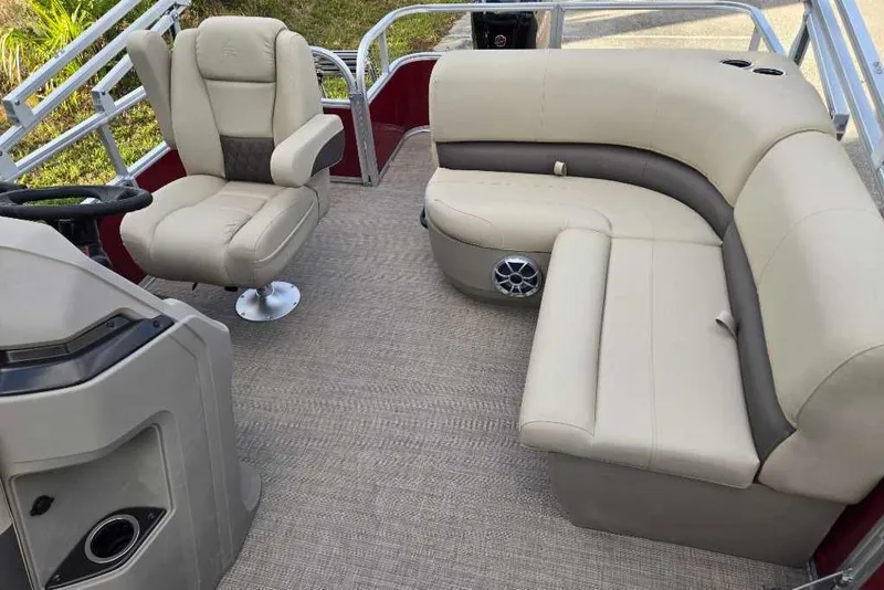 Slide: The Image of 2025 Sun Tracker Party Barge 18 DLX interior with beige seating and steering console. - 3