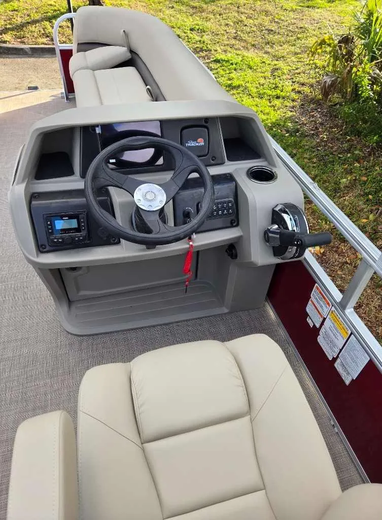 Slide: The Image of 2025 Sun Tracker Party Barge 18 DLX interior with steering console and seating. - 4