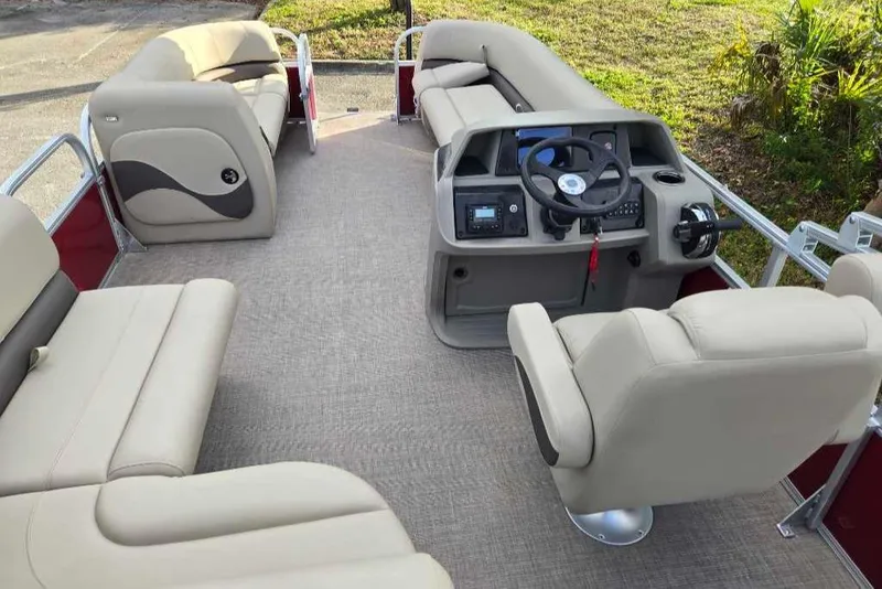 Slide: The Image of 2025 Sun Tracker Party Barge 18 DLX interior with beige seating and modern helm. - 5